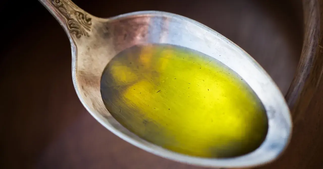 Łyżka z olejem lnianym, który może pomóc, gdy zastanawiasz się, czy olej lniany obniża cholesterol.