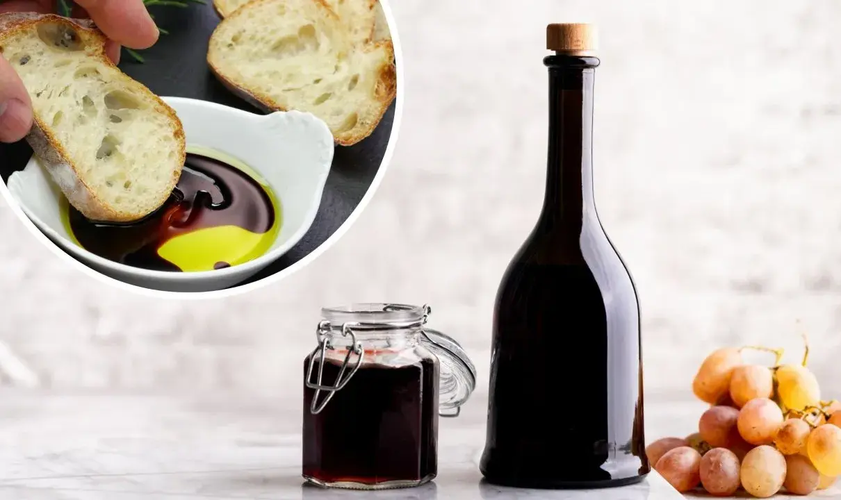 Chleb maczany w oliwie i occie balsamicznym, butelka i słoiczek z octem, kiść winogron. Ocet balsamiczny na czczo to zdrowy początek dnia.