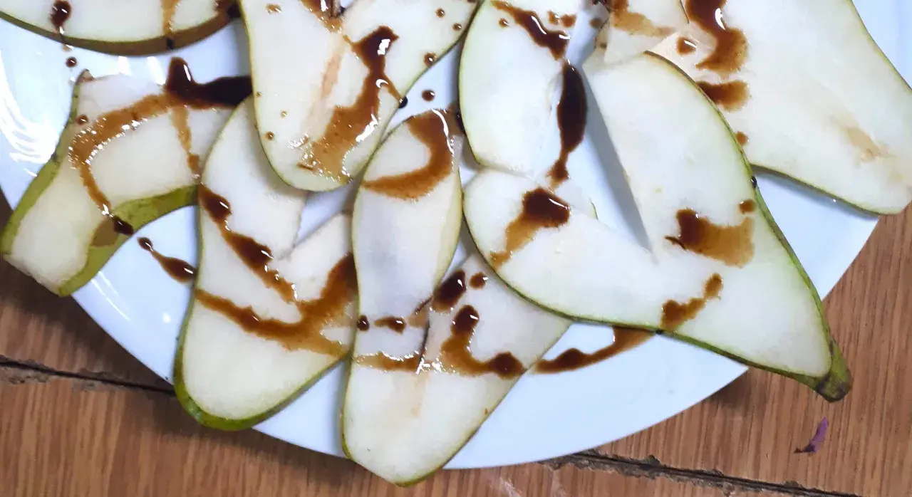 Kawałki gruszki polane ciemnym sosem, który zdradza, jak smakuje ocet balsamiczny – słodko-kwaśny, z nutą karmelu.