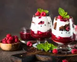 Pyszne fit desery bez pieczenia z malinami, borówkami i bitą śmietaną w szklanych pucharkach.