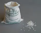 Worek z ryżem Carnaroli, idealnym do risotto. Kilka ziaren rozsypanych obok.
