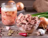 Słoik z mięsem i miska pełna smakołyków, cebula, czosnek, papryczki chili i liście laurowe. To składniki na obiady jak u babci przepisy.