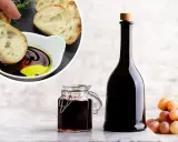 Chleb maczany w oliwie i occie balsamicznym, butelka i słoiczek z octem, kiść winogron. Ocet balsamiczny na czczo to zdrowy początek dnia.