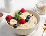 Pyszna owsianka z masłem orzechowym, bananem, malinami i borówkami. Idealne śniadanie pełne energii.