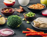 Składniki na dietę dr Budwig: brokuły, fasolka edamame, twaróg, jabłka, cebula, granola, suszone owoce, czekolada.