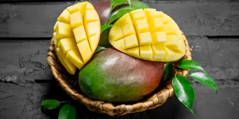 Koszyk z mango, jedno pokrojone w kostkę. Czy zastanawiasz się nad mango indeks glikemiczny?