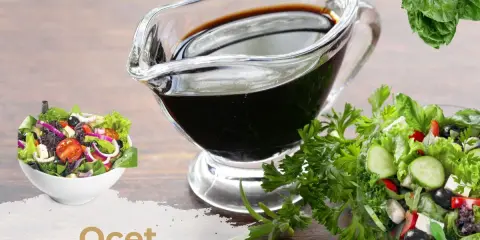 Gęsty ocet balsamiczny w sosjerce, obok sałatek i ziół. Dowiedz się, jak zrobić gęsty ocet balsamiczny.