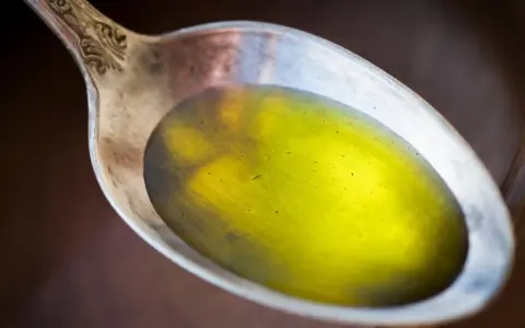 Łyżka z olejem lnianym, który może pomóc, gdy zastanawiasz się, czy olej lniany obniża cholesterol.