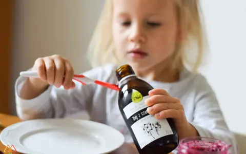 Mała dziewczynka trzyma butelkę oleju z czarnuszki. Od jakiego wieku można go podawać?