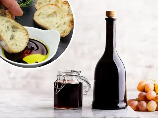 Chleb maczany w oliwie i occie balsamicznym, butelka i słoiczek z octem, kiść winogron. Ocet balsamiczny na czczo to zdrowy początek dnia.