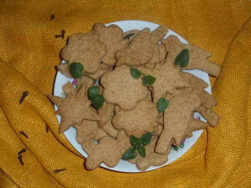 Ciasteczka orkiszowe św. Hildegardy na talerzu, ozdobione listkami mięty. Przepis na te zdrowe wypieki jest w zasięgu ręki!