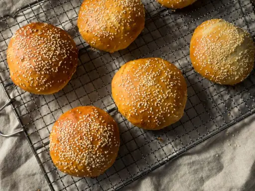 Bułeczki z mąki orkiszowej posypane sezamem, idealne na burgery lub jako dodatek do posiłków. Co można zrobić z mąki orkiszowej? Pyszne wypieki!