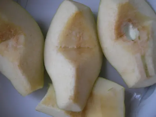 Kawałki pigwy, gotowe do przetworzenia. Ich kwaskowaty aromat sugeruje, jak smakuje pigwa – orzeźwiająco i lekko cierpko.