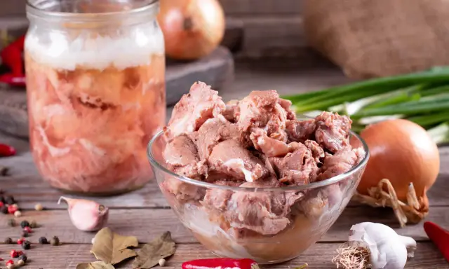Słoik z mięsem i miska pełna smakołyków, cebula, czosnek, papryczki chili i liście laurowe. To składniki na obiady jak u babci przepisy.