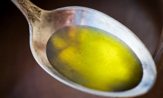 Łyżka z olejem lnianym, który może pomóc, gdy zastanawiasz się, czy olej lniany obniża cholesterol.