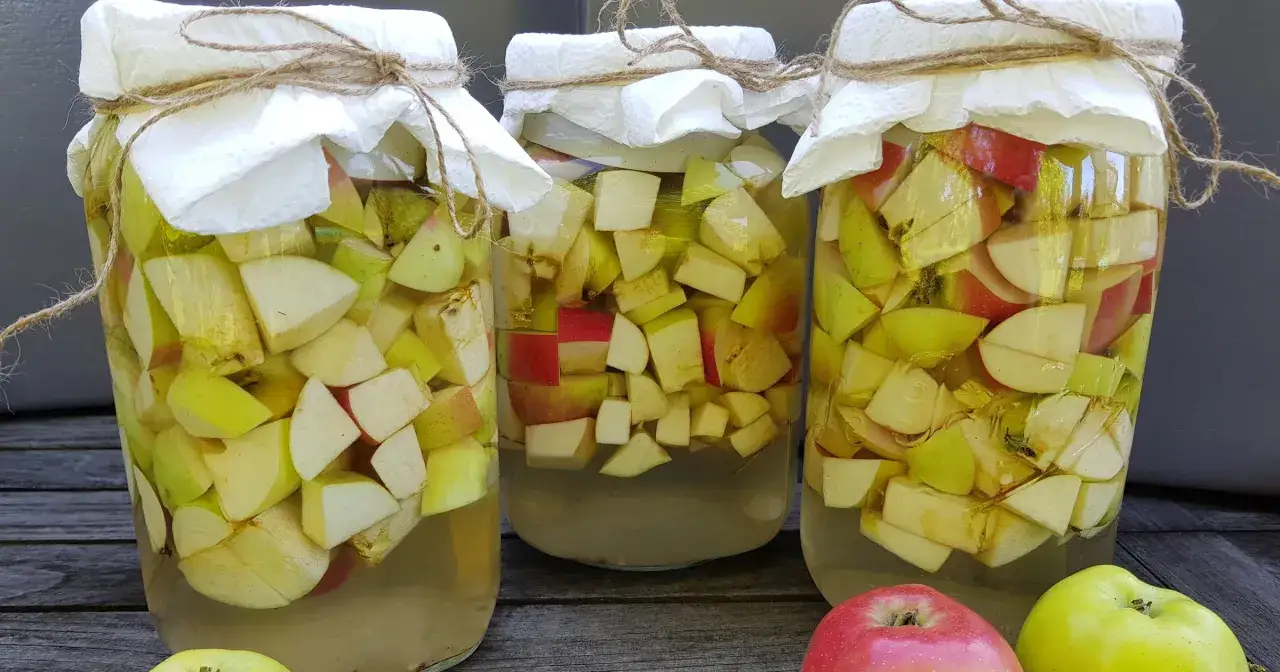 Trzy słoje z pokrojonymi jabłkami, przygotowywane do fermentacji. Powstaje naturalny ocet jablkowy.