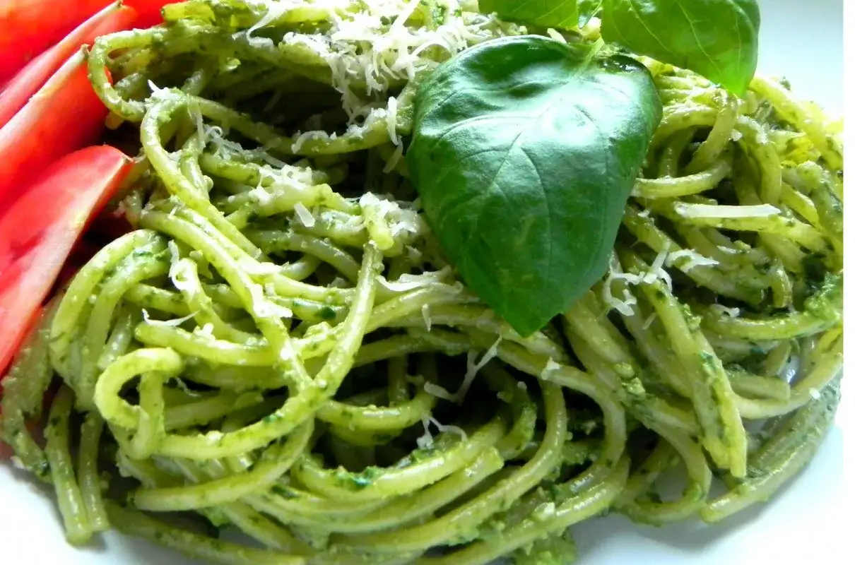 Makaron z sosem pesto, posypany parmezanem i udekorowany listkami bazylii. Pesto co to? To aromatyczny sos z bazylii, orzeszk&oacute;w, czosnku i oliwy.