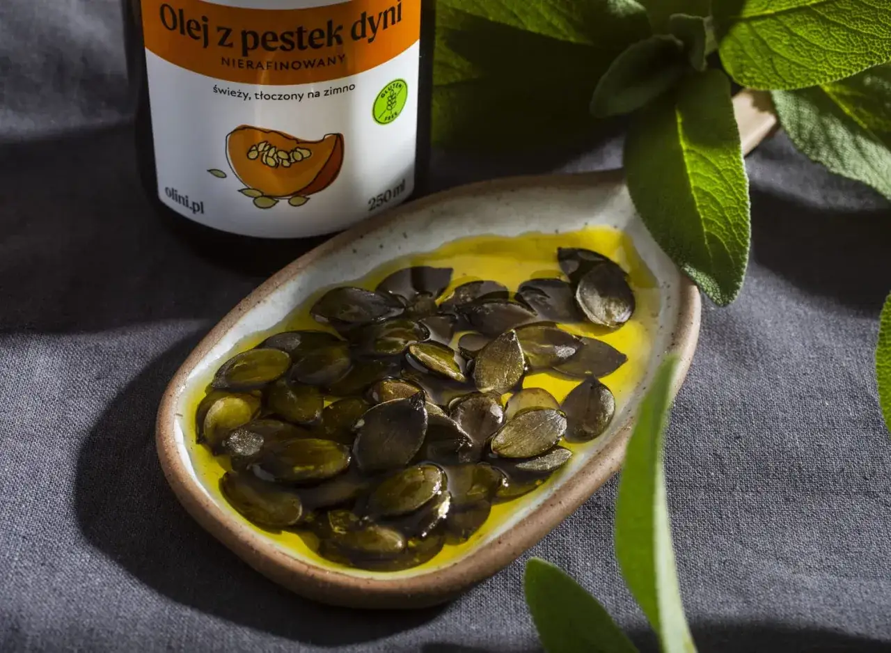 Olej z pestek dyni w miseczce z pestkami. Warto znać olej z pestek dyni przeciwwskazania przed jego stosowaniem.